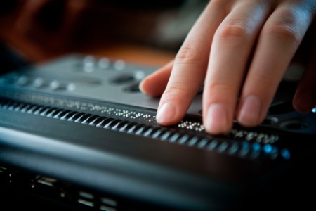 Person arbeitet an Braille-Laptop